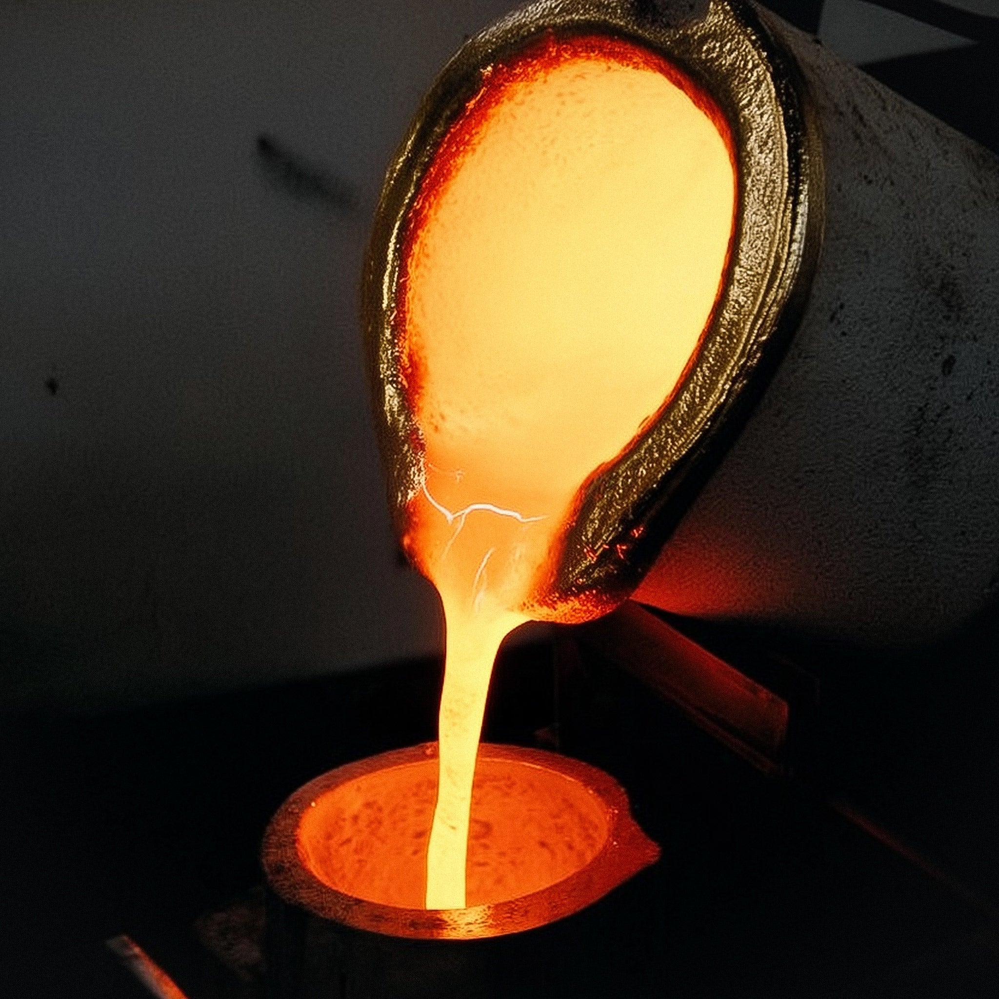 Molten silver being poured from a crucible into a mold, symbolizing the raw creation process of Cast Pieces™ jewelry in Sweden.