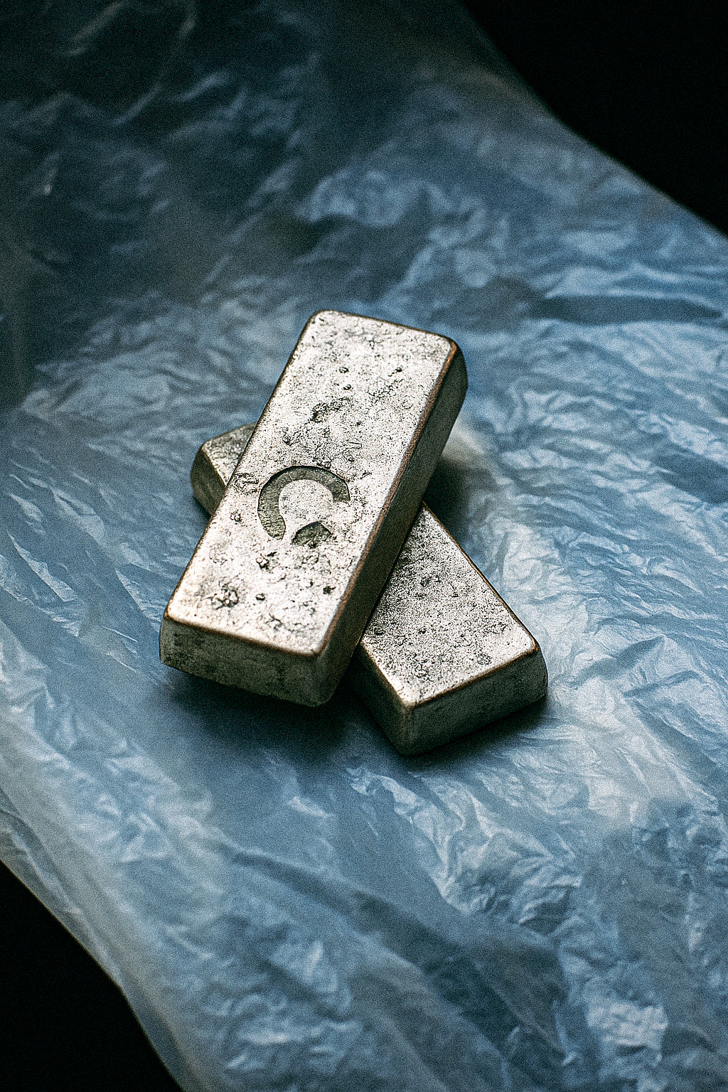 Two raw silver ingots engraved with the Cast Pieces™ C logo, representing the origin of graffiti-inspired jewelry in silver and gold.