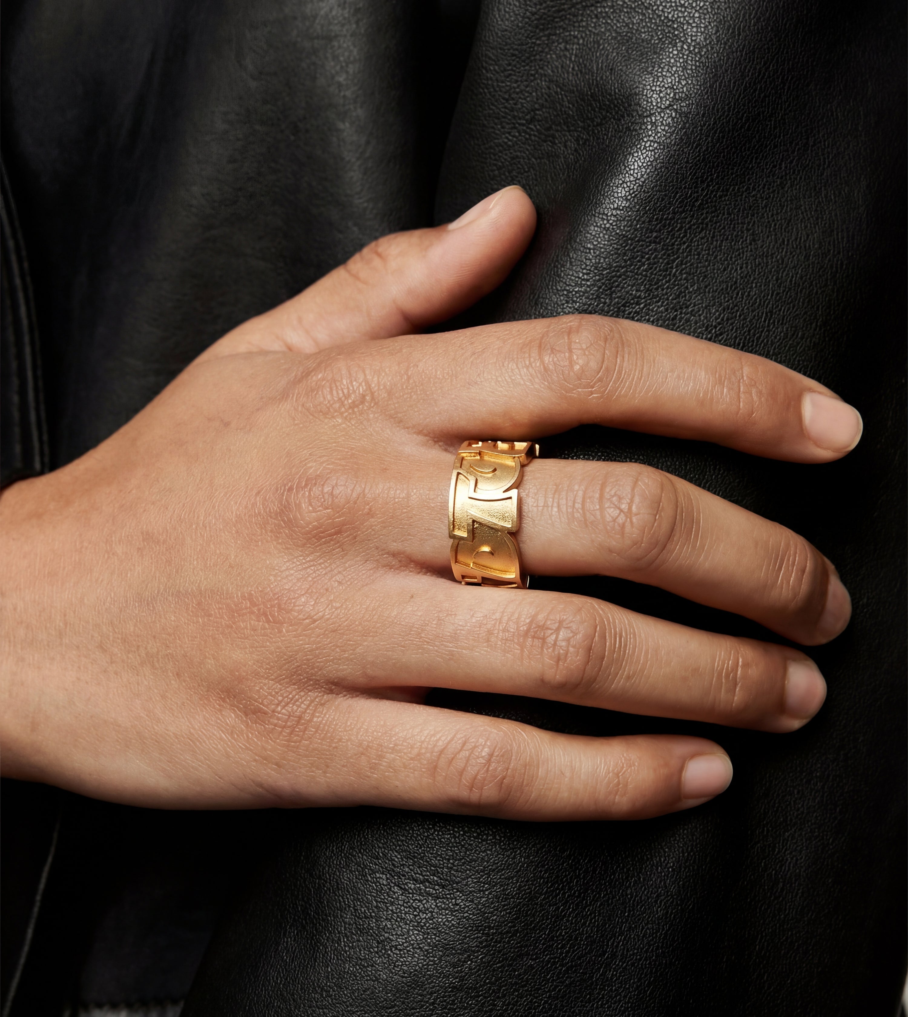 End to End block letters gold ring by Cast Pieces, worn by model